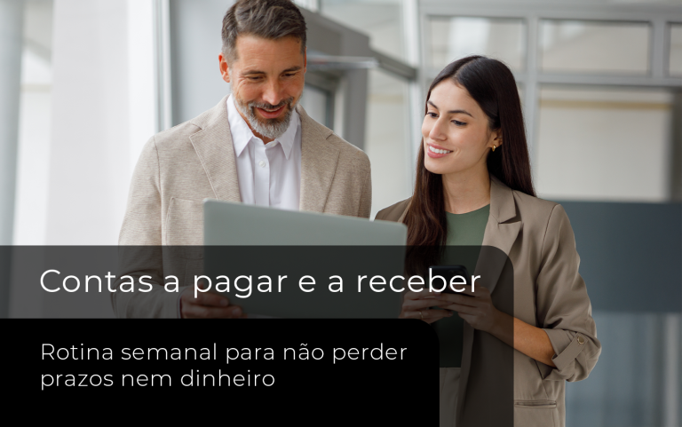 Dois profissionais analisam informações financeiras em um notebook e um celular, representando a organização e o acompanhamento de contas a pagar e receber.