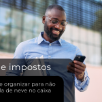 Profissional consulta informações no celular enquanto segura documentos, representando a organização e o acompanhamento do DAS Simples Nacional.