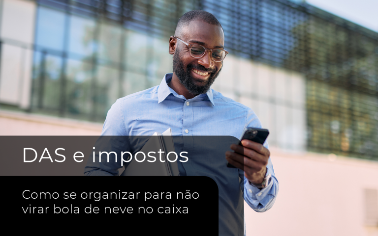Profissional consulta informações no celular enquanto segura documentos, representando a organização e o acompanhamento do DAS Simples Nacional.